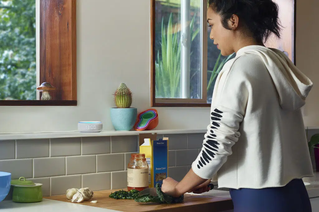 Mulher na cozinha com o novo amazon echo dot com relógio