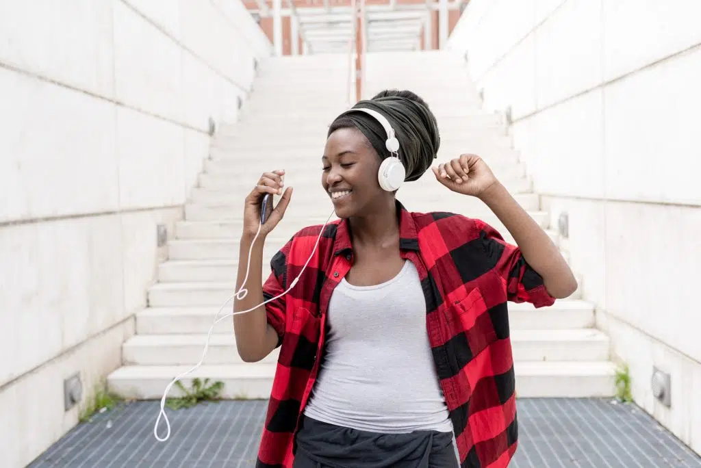 Uma jovem escuta música, se divertindo muito com isso