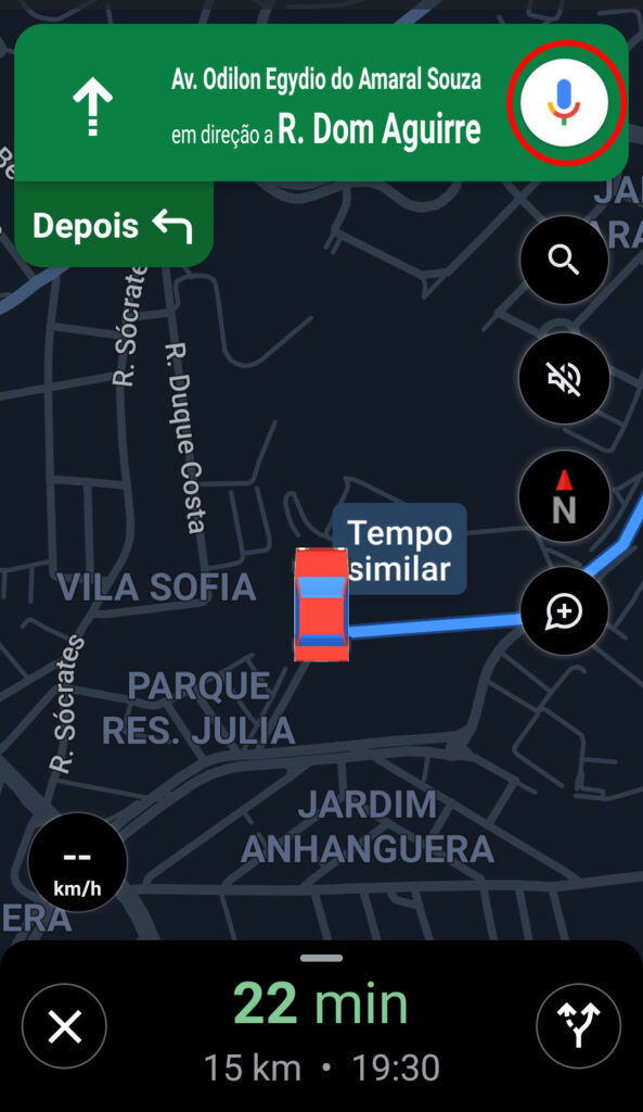 Captura de tela do aplicativo google maps com uma rota traçada entre dois pontos em mapa da cidade de são paulo. Em destaque no canto superior direito, contornado por um círculo vermelho, o ícone de um microfone.