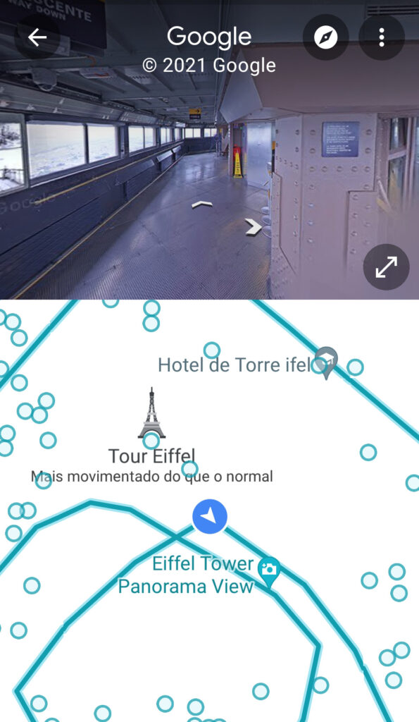 Captura de tela do aplicativo google maps com street view da torre eiffel com duas setas na parte superior. Na parte inferior, o mapa da torre eiffel com linhas em azul petróleo e um ícone azul índigo sobre uma das linhas.