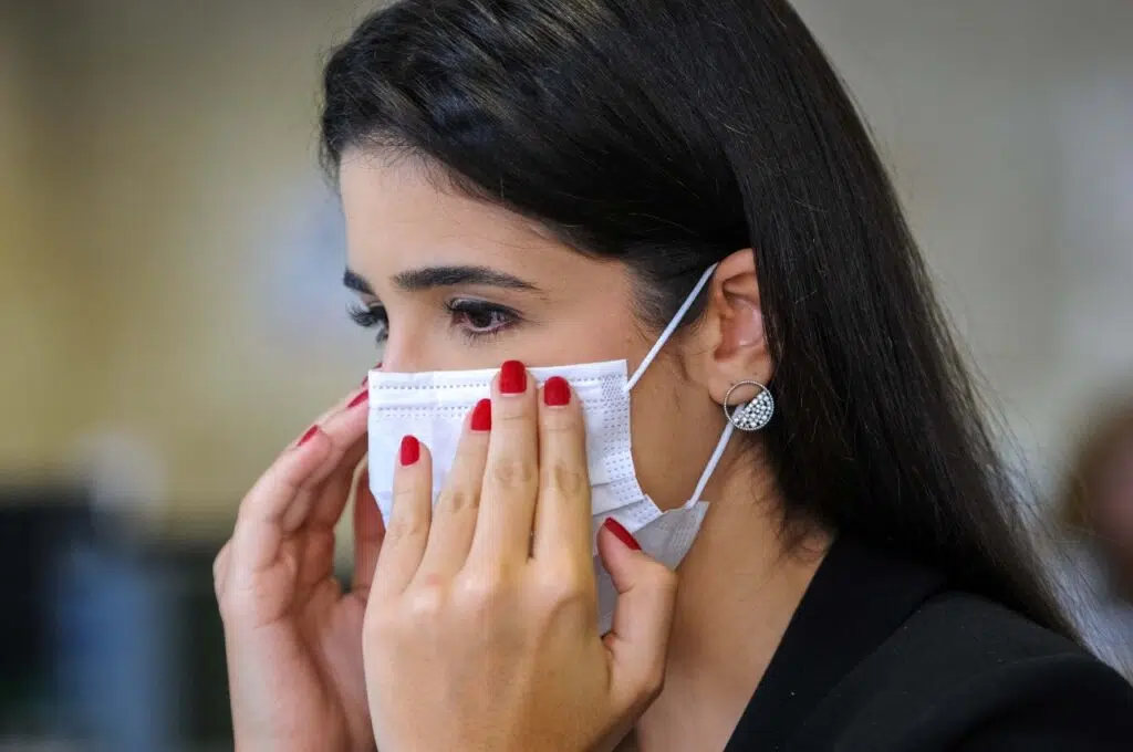 Mulher realizando uso de máscara em trabalho