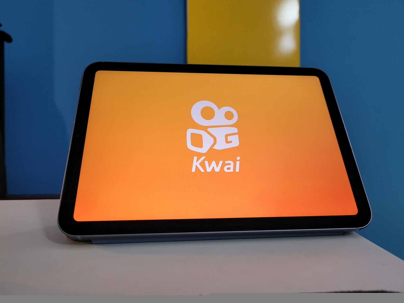 Kwai app on smartphone screen on orange background. Social media