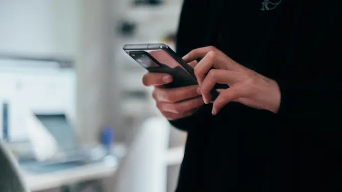 Homem mexendo em celular em público