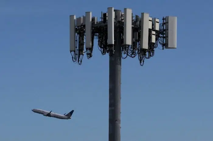 Avião voando próximo a uma torre 5g