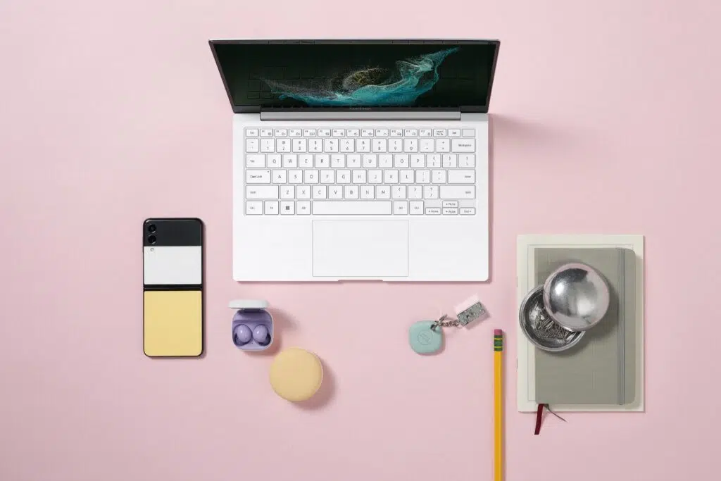 Galaxy book2 pro em um fundo rosa ao lado de outros aparelhos fabricados pela samsung