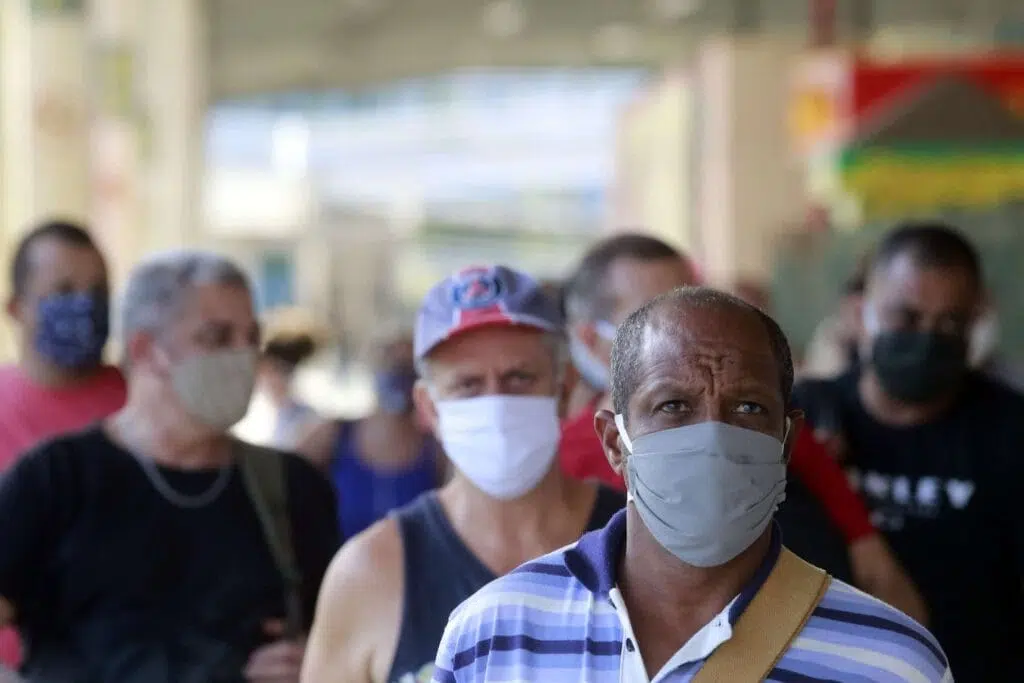 Pessoas fazendo o uso de máscara em terminal de ônibus do rio de janeiro