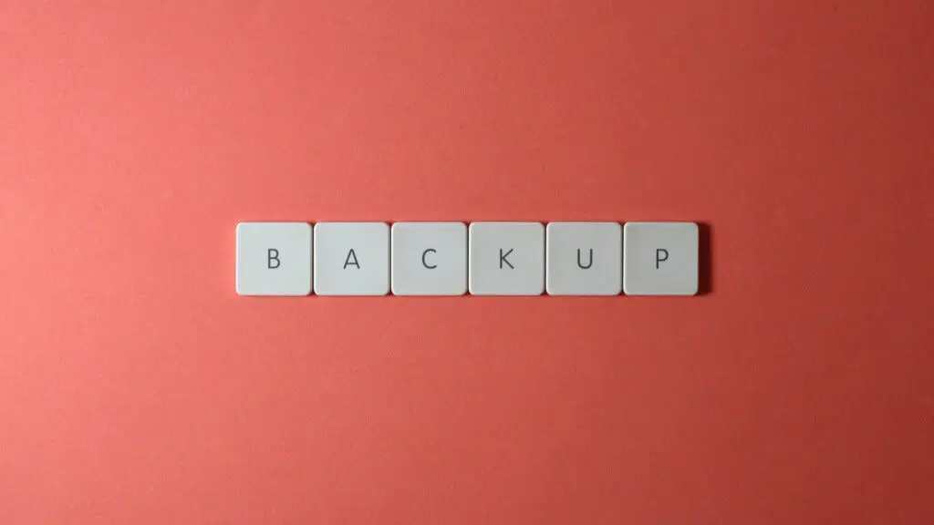 Teclas de teclado com frase backup escrita, sobre um fundo rosa