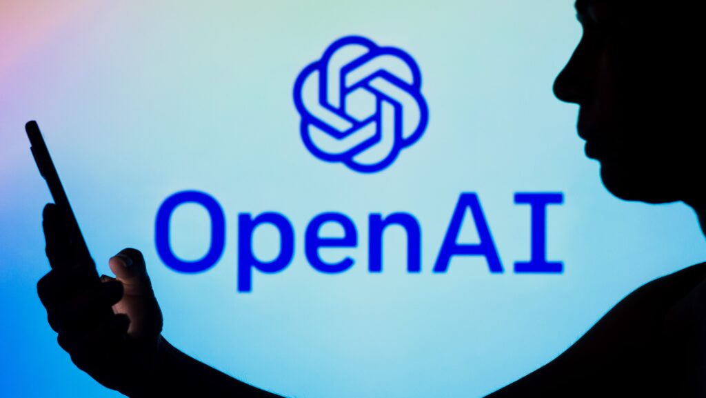 Pessoa usando celular e logo da openai de fundo - imagem ilustrativa