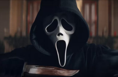 Cena do vilão "ghostface" em "pânico 6". O personagem está próximo da câmera, segurando uma faca.