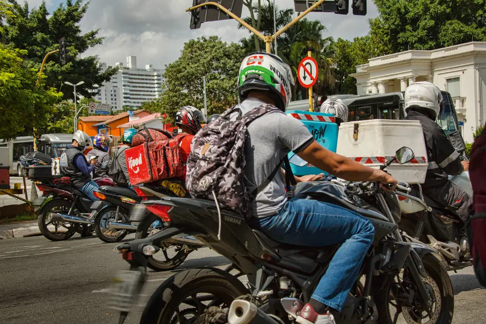 Foto de entregadores de comida parados em trânsito na cidade de são paulo