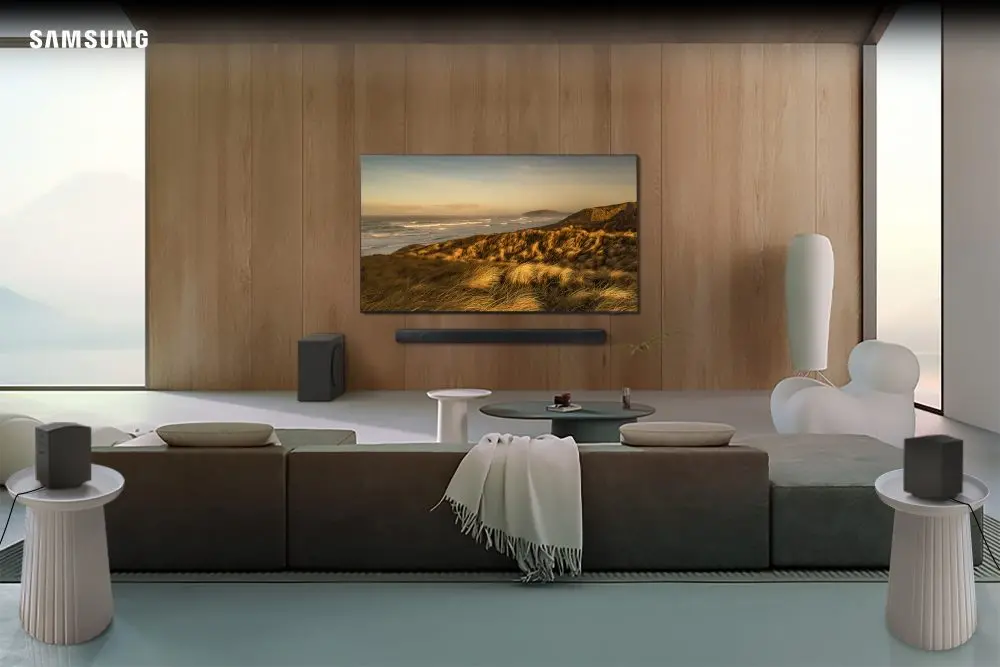 A imagem mostra uma soundbar samsung instalada em uma sala a fim de ilustrar a matéria a respeito dos novos dispositivos de áudio da categoria da gigante coreana.