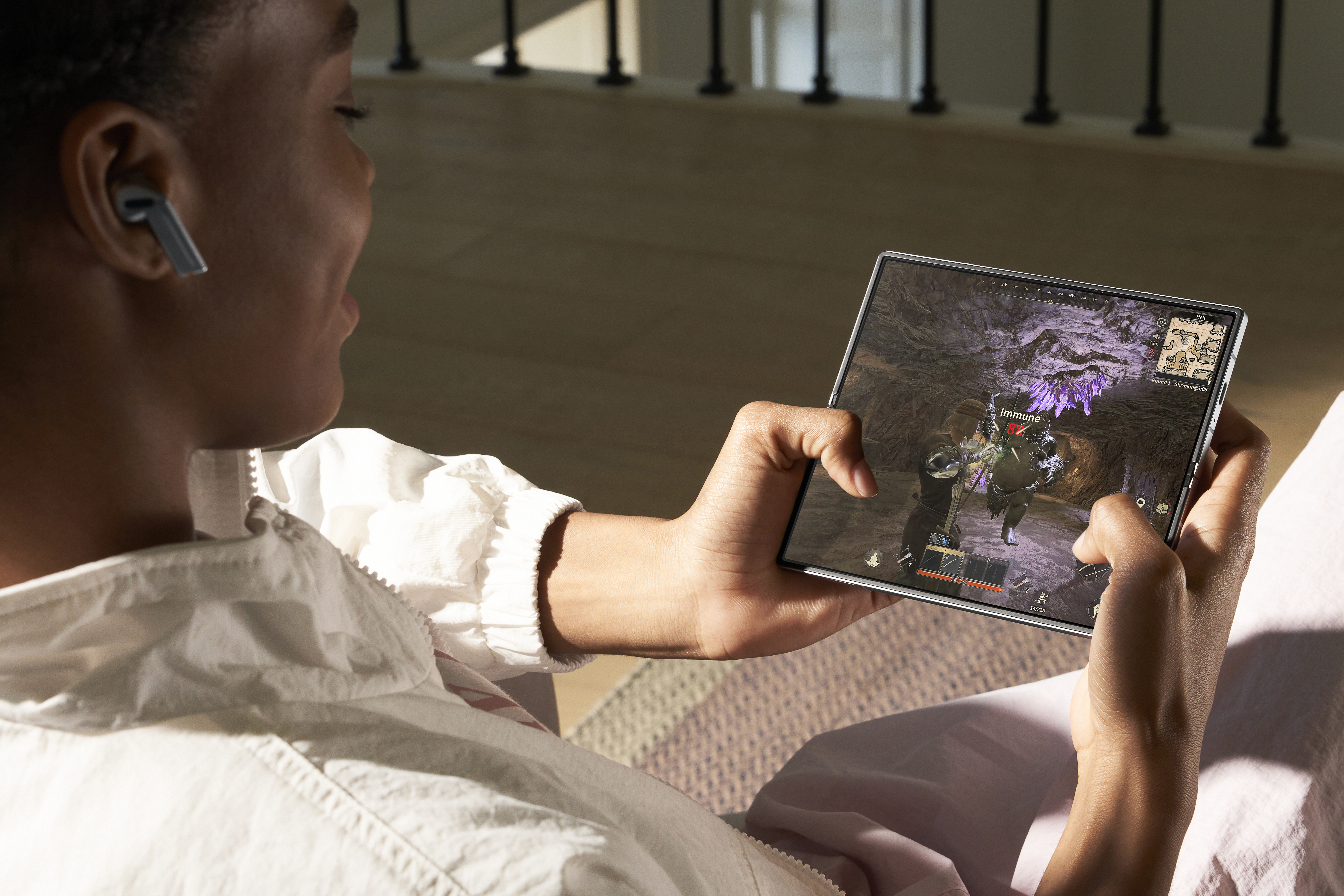 Homem negro jogando em smartphone e usando os galaxy buds3 pro