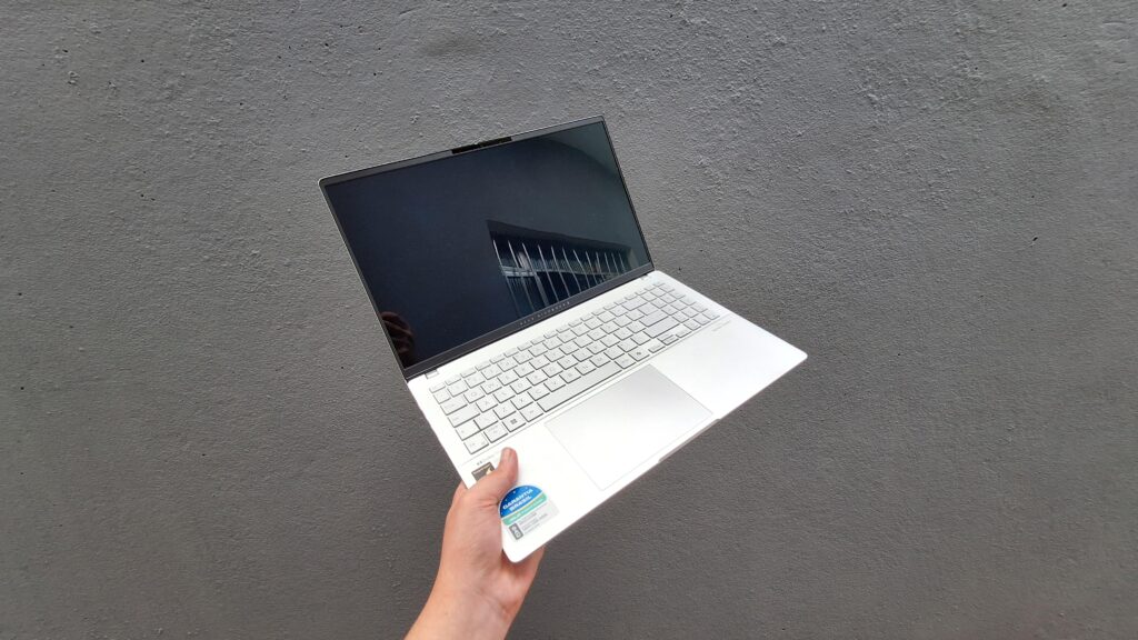 Asus vivobook s 15 em fundo cinza segurado por homem