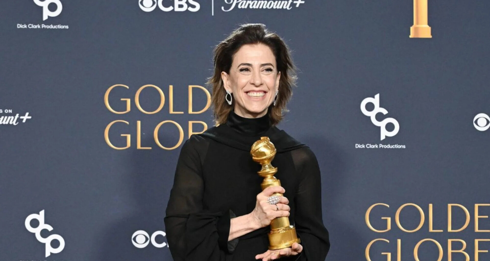 Fernanda torres segurando o troféu do globo de ouro