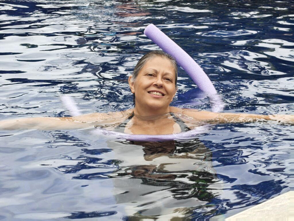 Mulher em piscina com macarrão roxo